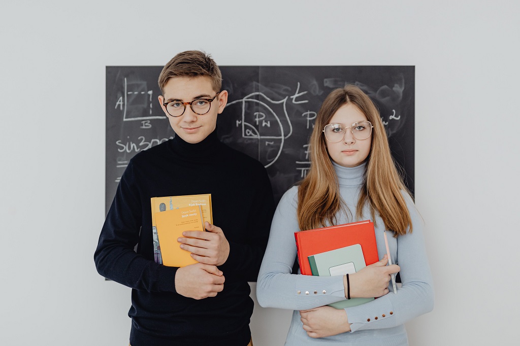 Male and female college students holding books